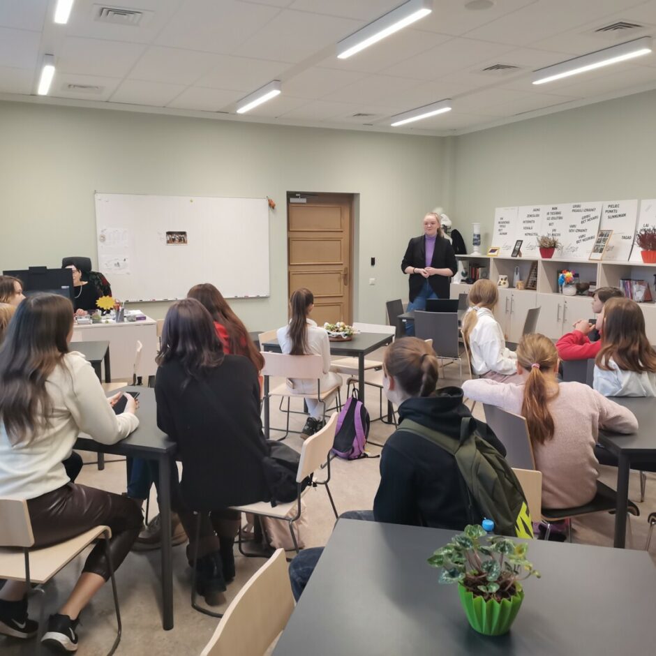 Bērni klasē sēž pie galdiem