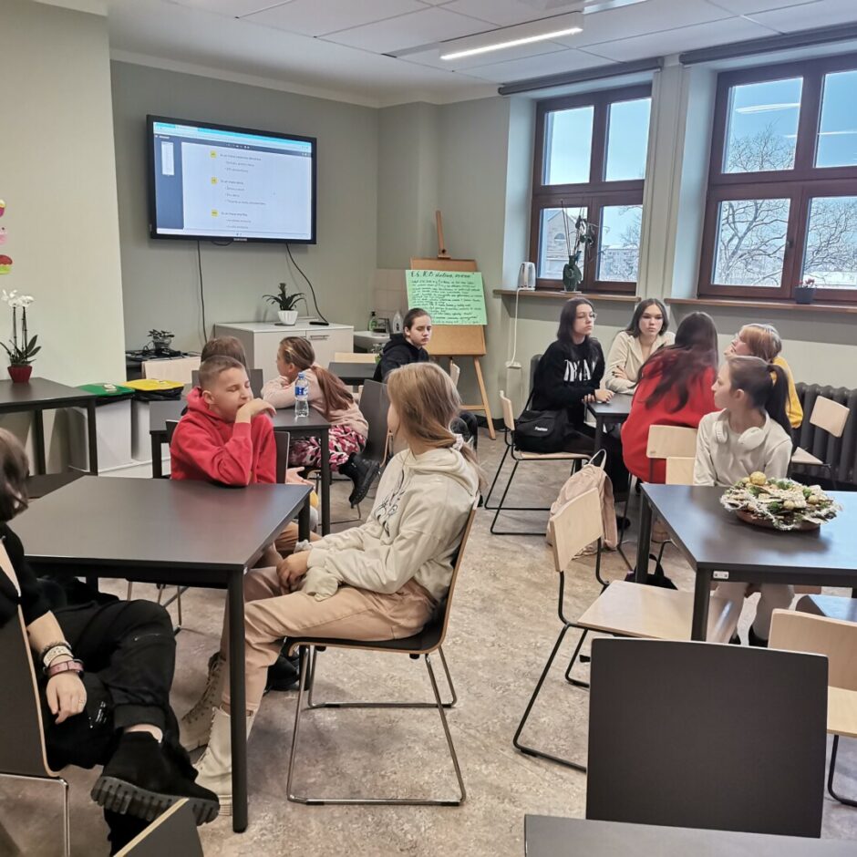 Bērni klasē sēž pie galda