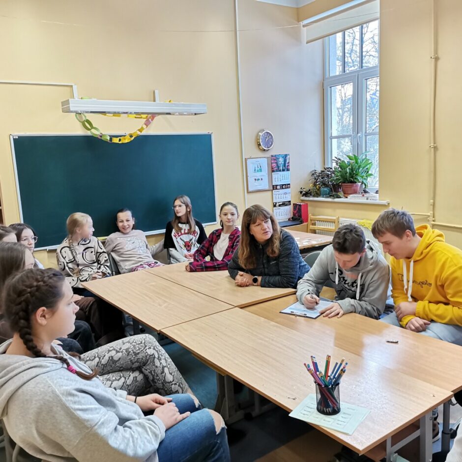 Bērni un sieviete pie galda