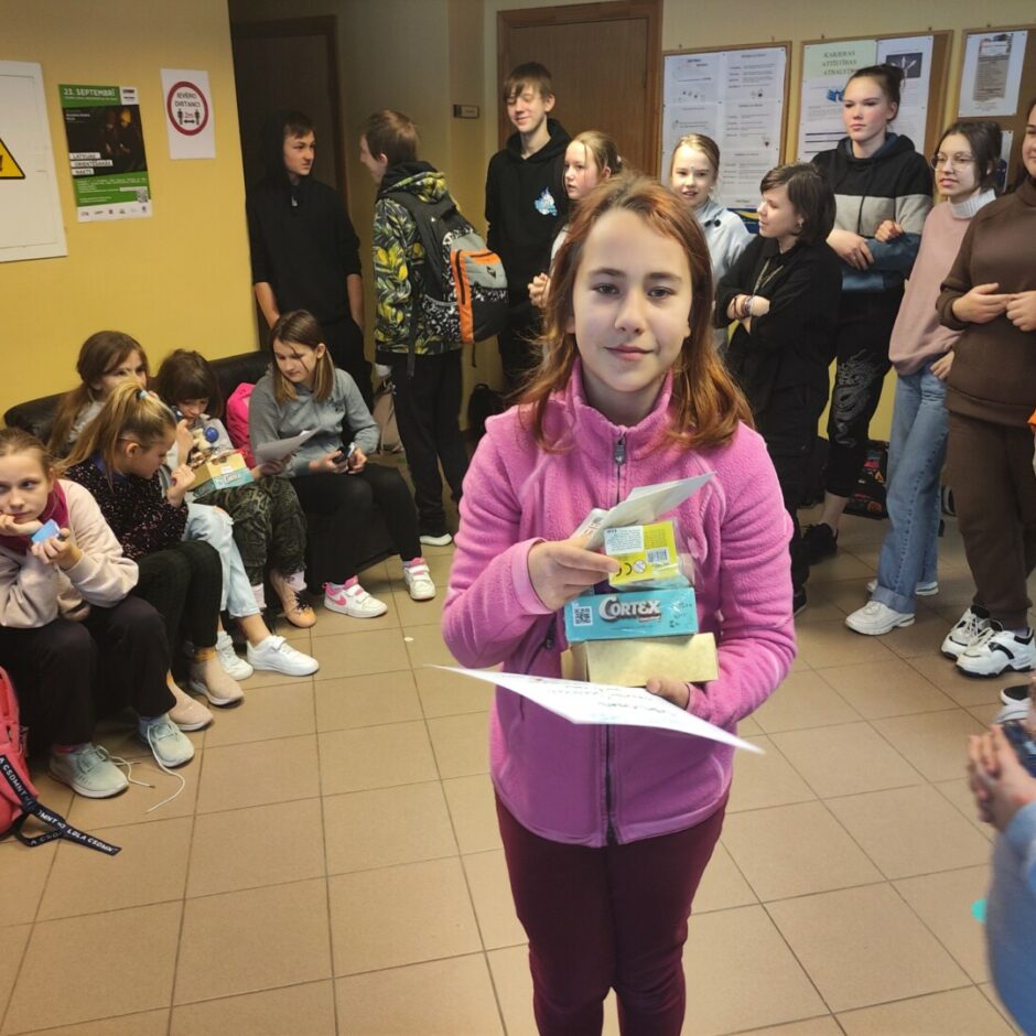 Meitene ar balvām rokās