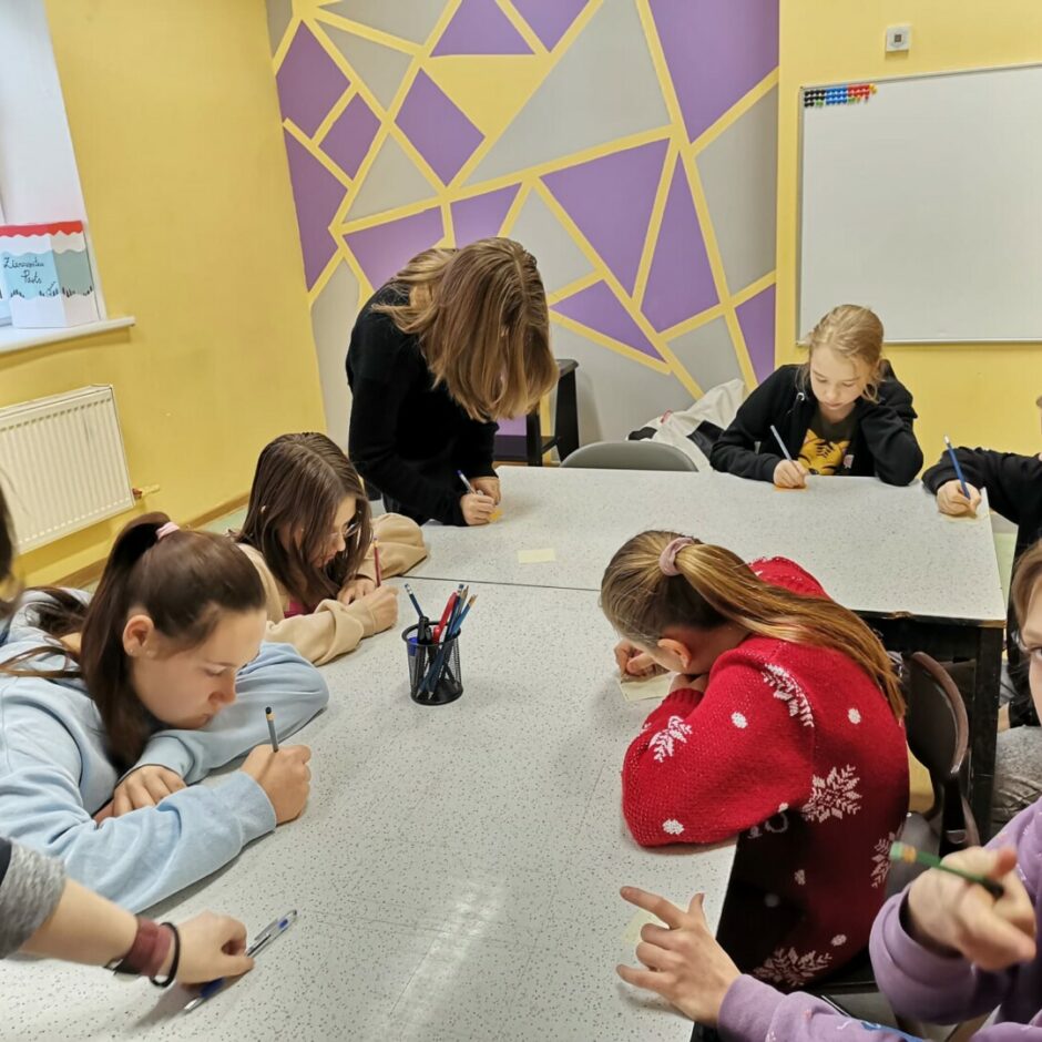 Bērni pie galda raksta