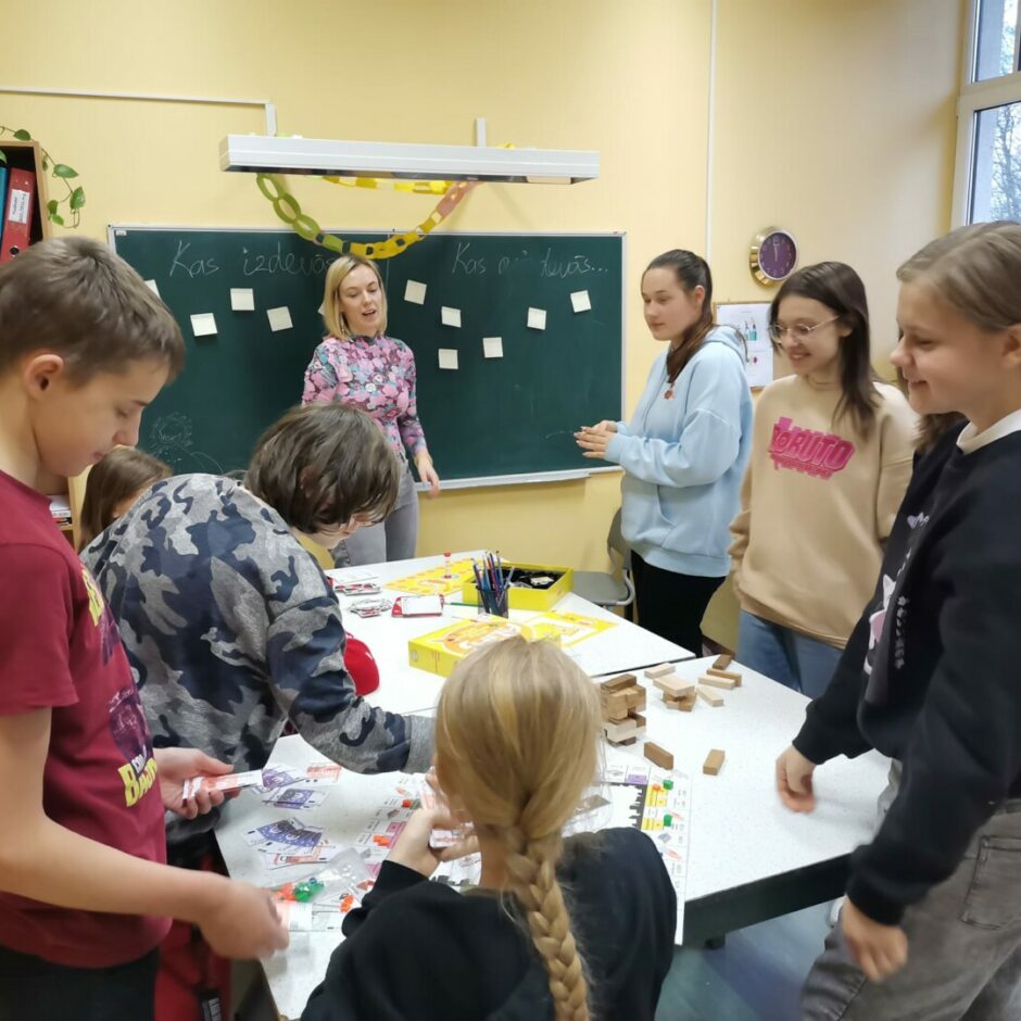 Bērni pie galda spēlē spēles