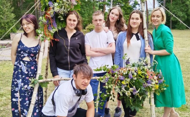 Skolēni un skolotāja starp kokiem
