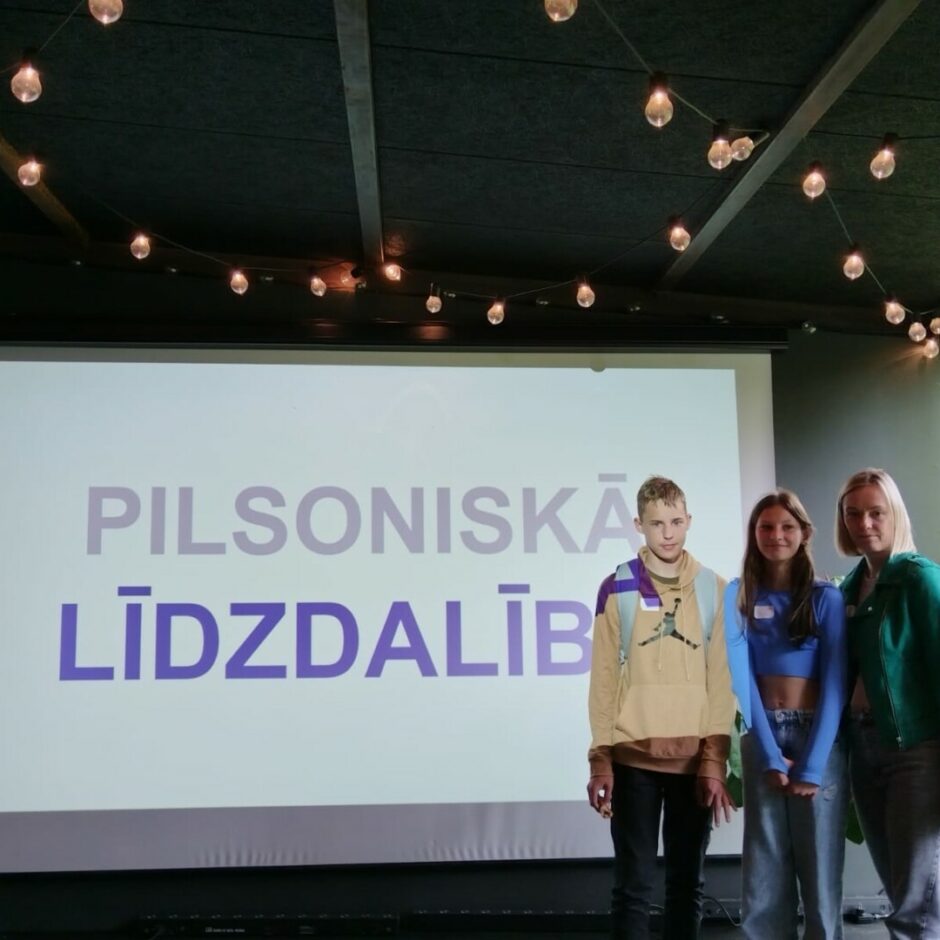 Sieviete ar bērniem stāv uz skatuves