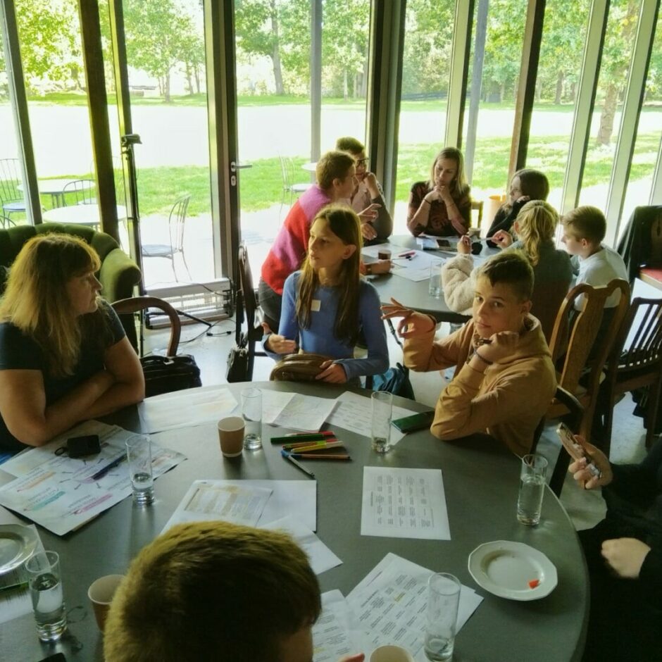 Pie galda sēž cilvēki