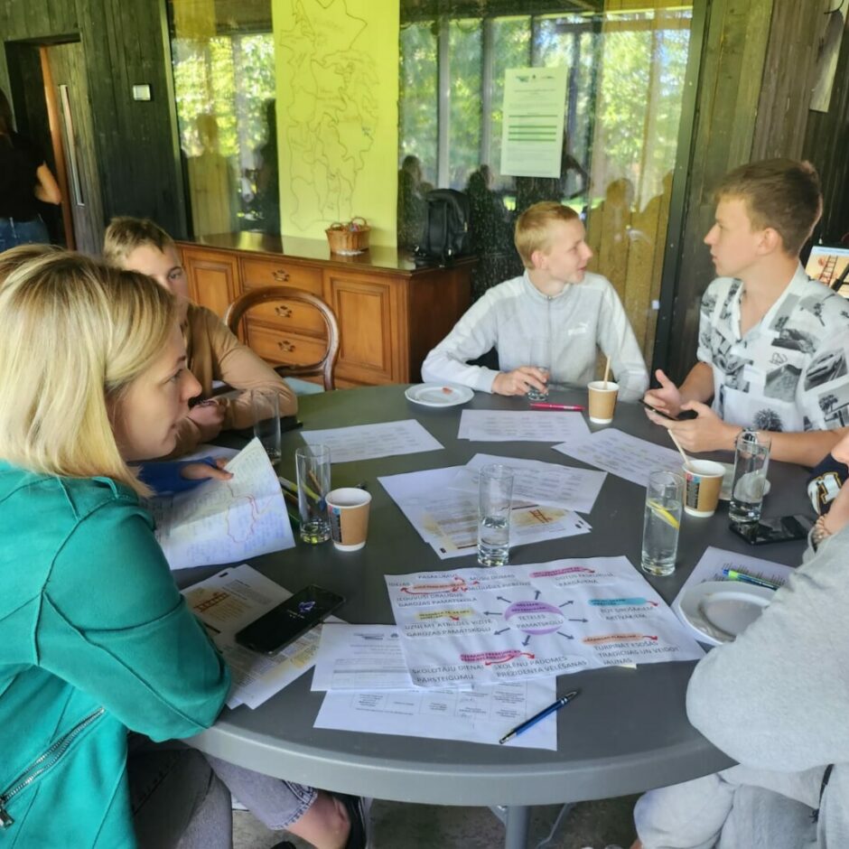 Pie galda sēž cilvēki