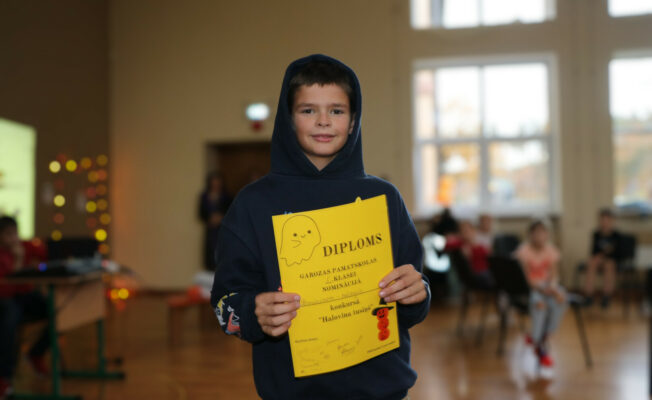 Zēns ar diplomu rokās