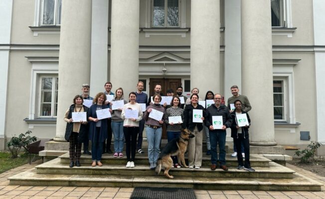 Cilvēki pie iestādes ar diplomiem